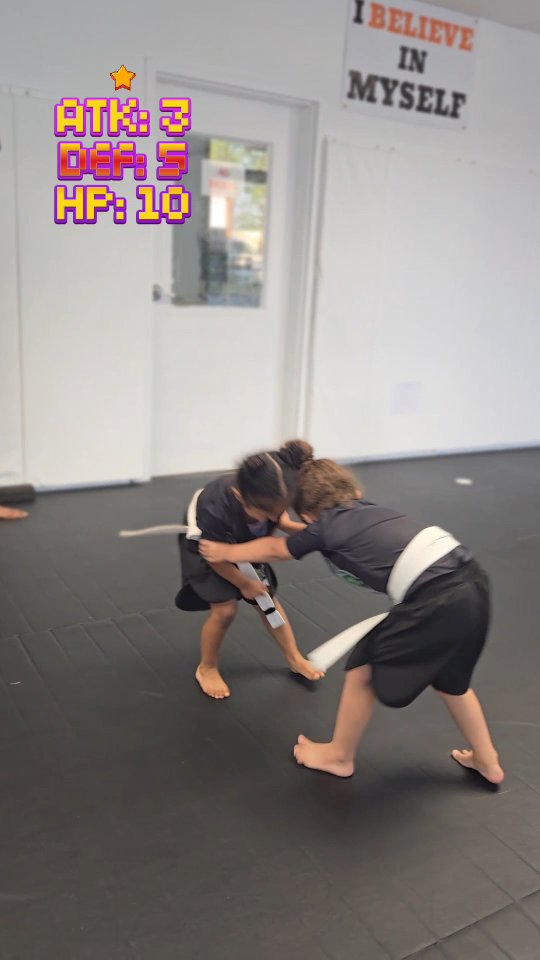 Girls wrestling class at Sodiq Yusuff MMA in front of I Believe In Myself banner