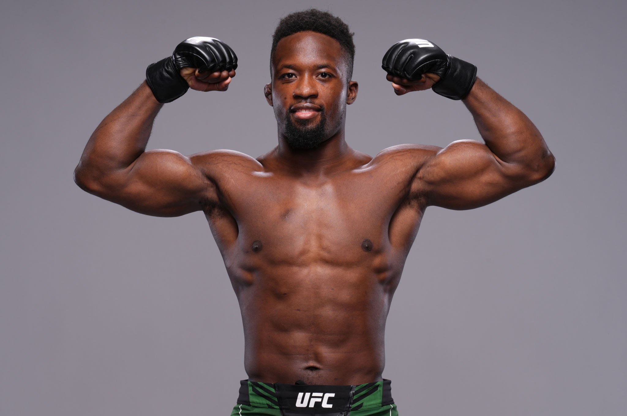 Sodiq Yusuff UFC portrait — flexing in Octagon, UFC fight gloves, Nigerian flag fight shorts